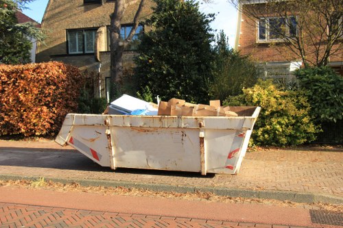 Team loading a commercial bin onto a covered collection vehicle